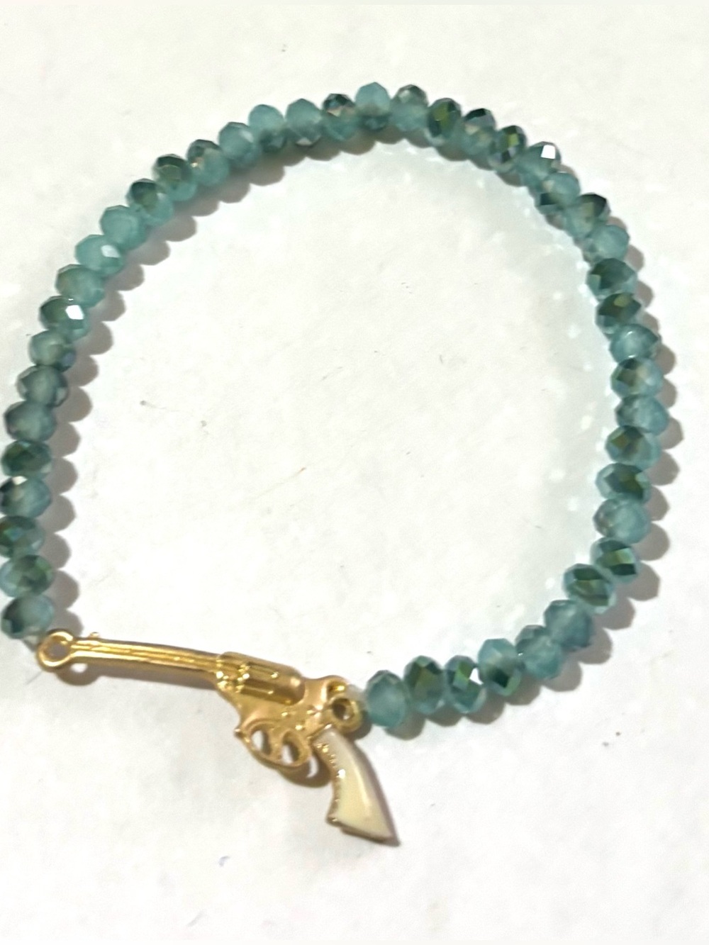 Teal Faceted Bead Stretch Bracelet with Gold Pistol Charm